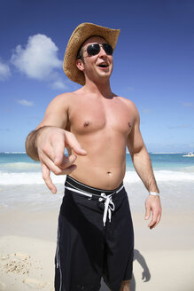 Man standing on beach, pointing - PKF00041