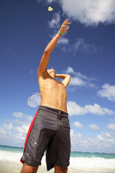 Junger Mann spielt Batminton am Strand - PKF00009