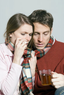 Junges Paar mit einer Erkältung trinkt Tee - NHF00519