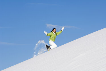 Frau mit Schneeschuhen, bergauf laufend - HHF01382