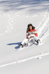 Woman tobogganing in mountains - HHF01359