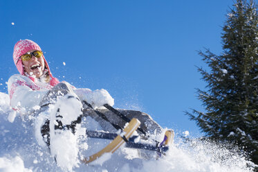 Woman tobogganing in mountains - HHF01305