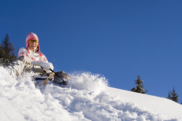 Woman tobogganing in mountains - HHF01304