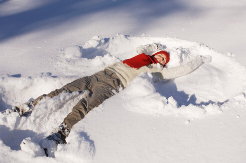 Frau im Schnee liegend - HHF01293