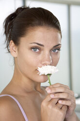 Junge Frau riecht an einer Blüte, Nahaufnahme - WESTF05149