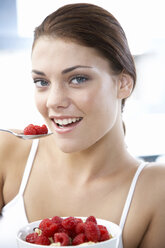 Young woman holding bowl with rasberries - WESTF05051