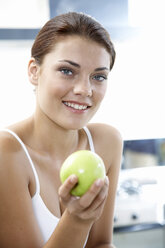 Young woman holding apple - WESTF05037