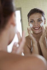 Young woman applying face cream - WESTF05019