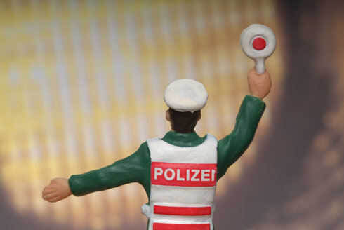 Police figurine in front of automobile headlight - TCF00013