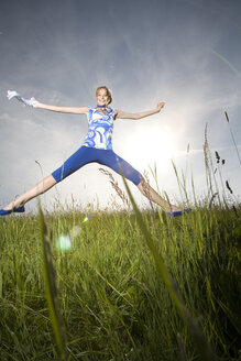 Woman cutting a caper in the meadow - MAEF00377