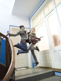 Zwei Mädchen springen auf einer Treppe - KMF00938