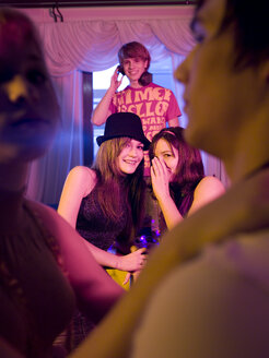 Junge Frauen tuscheln auf einer Party - KMF00912