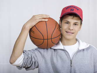 Junge ( 16-17), der einen Basketball hält, Porträt - KMF00885