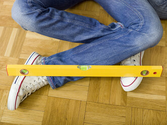 Woman sitting on floor with water level on feet, low section - WESTF05169