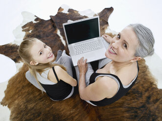 Grandmother and granddaughter using laptop, portrait - WESTF05377