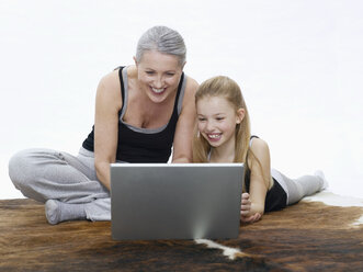 Grandmother and granddaughter using laptop, portrait - WESTF05375