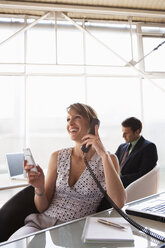 Business woman phoning, male colleague in background - WESTF05599