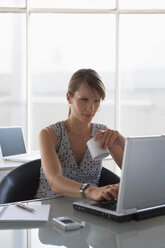 Frau mit Laptop und Tasse in der Hand - WESTF05552