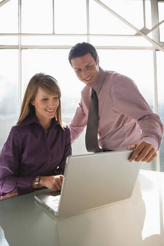 Geschäftsleute, die einen Laptop benutzen, Teamarbeit, lizenzfreies Stockfoto