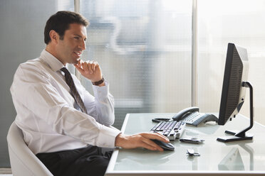 Business man sitting at desk, portrait - WESTF05439