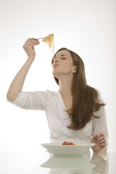 Woman eating noodles, portrait - CLF00381