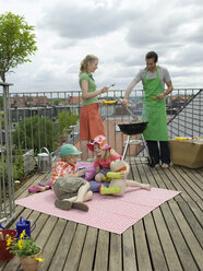 Ehepaar mit Kindern auf dem Balkon, beim Grillen - WESTF05929