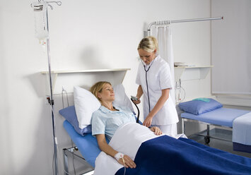 Krankenschwester prüft Blutdruck einer Patientin - WESTF05660