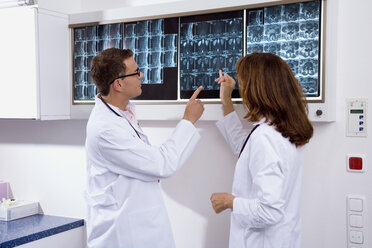 Ein männlicher Arzt und eine Ärztin untersuchen einen Röntgenbericht - WESTF05615