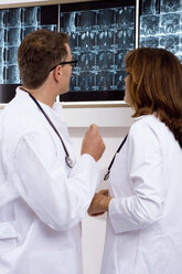 Ein männlicher Arzt und eine Ärztin untersuchen einen Röntgenbericht - WESTF05614