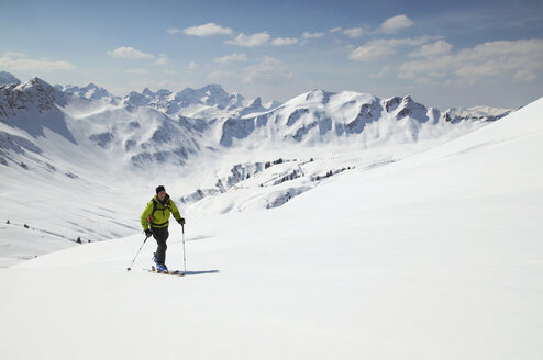 Österreich, Kleinwalsertal, Mann beim Skifahren in den Alpen - MRF00932