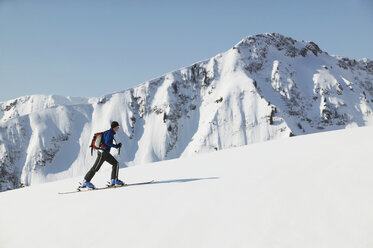 Österreich, Kleinwalsertal, Mann beim Skifahren in den Alpen - MRF00929