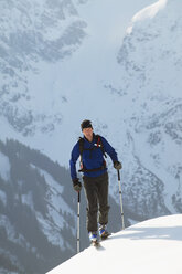 Österreich, Kleinwalsertal, Mann beim Skifahren in den Alpen - MRF00928