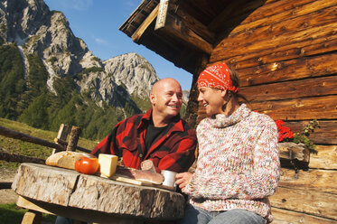 Couple sitting in front of alpine hut - HHF01493