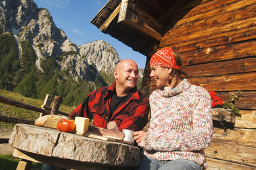 Ehepaar vor einer Berghütte sitzend - HHF01493