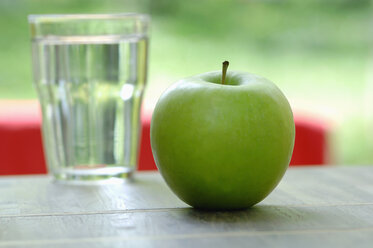 Grüner Apfel, neben einem Glas Wasser, Nahaufnahme - ASF03269