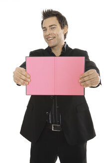 Man holding pink notebook, close-up - PKF00130