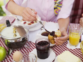 Frau schmiert Marmelade auf Croissant - WESTF06130