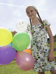 Girl holding balloons, portrait - WESTF06046