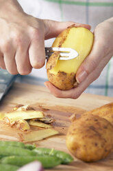 Man peeling potatoes, close-up - THF00607