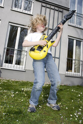 Junge 10-11) spielt auf Spielzeuggitarre - NHF00545