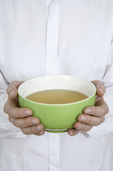 Hands holding tea bowl - TCF00170