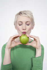 Young woman holding a green apple, portrait - TCF00160