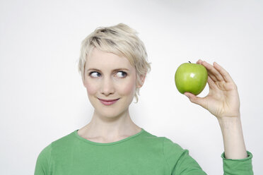 Young woman holding a green apple, portrait - TCF00156