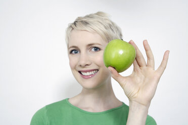 Young woman holding a green apple, portrait - TCF00155