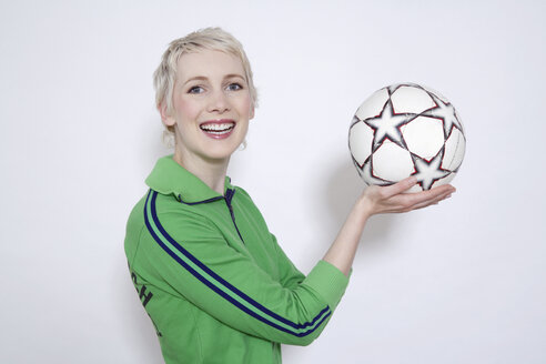 Junge Frau hält Fußball, Porträt - TCF00152