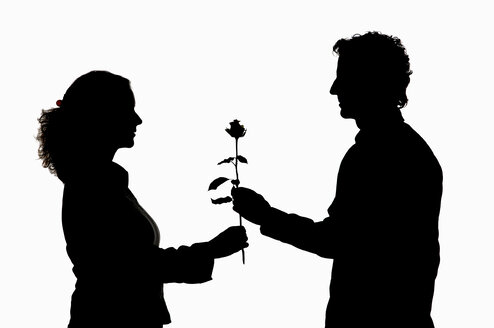 Man giving rose to woman, silhouette - CRF01321