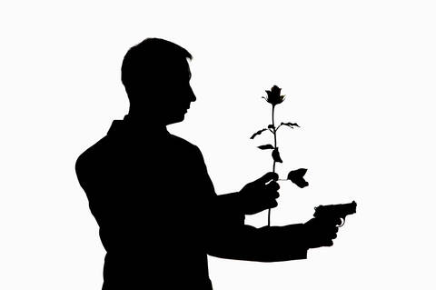 Mann mit Gewehr und Rose, Silhouette, lizenzfreies Stockfoto