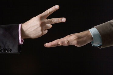 Businessmen playing rock paper scissors, close-up of hands - CLF00464