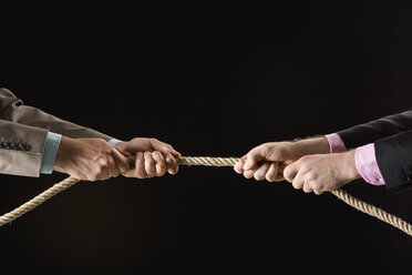 Businessmen pulling rope, close-up stock photo