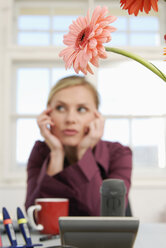 Woman sitting in office, thinking - VRF00050